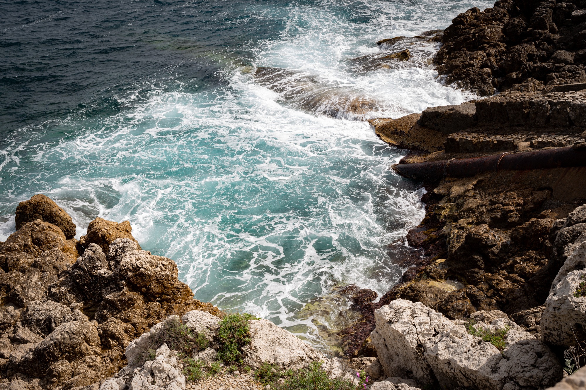 The starting photograph of waves and limestone, before this Façade edit.
