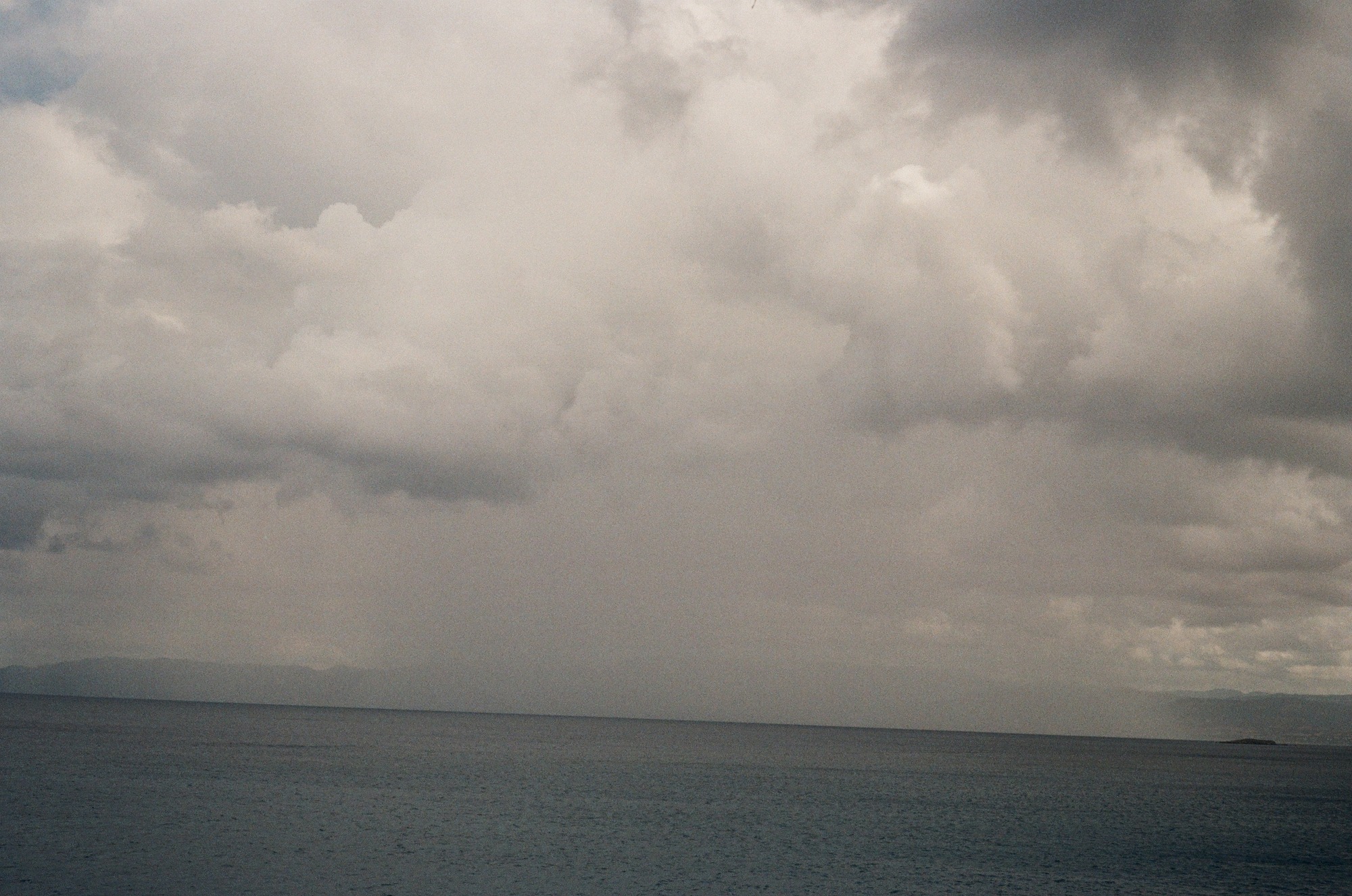 The original sea photograph, with warmer, softer cloud tones and a tilted horizon.