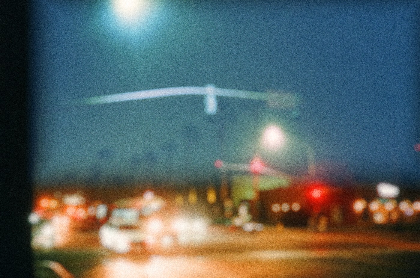 Soft blue evening street with warm lights and visible grain